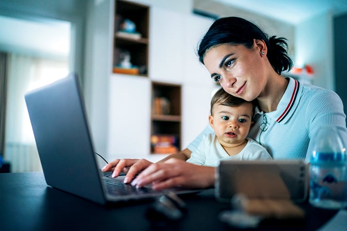 woman with child on lap looking at laptop